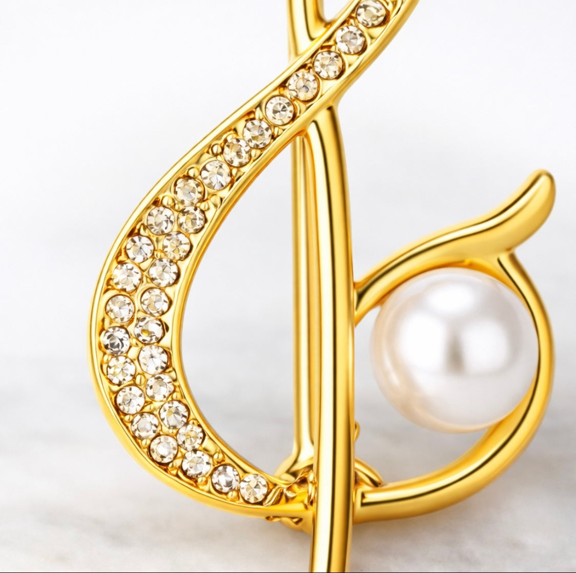 Goldene Notenschlüssel-Brosche mit Perle – Fleur d'Estime